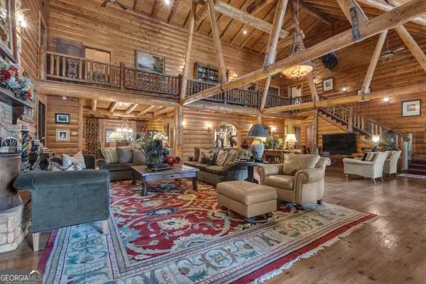 a room with furniture gym equipment wooden floor and a rug