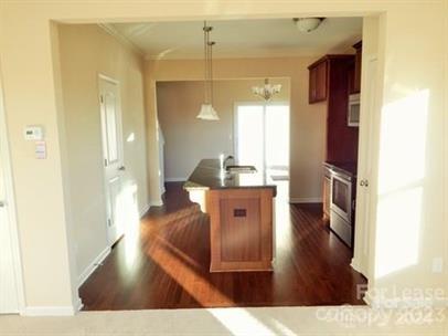 5204 Prosperity Church Road Charlotte, NC 28269 - Photo 3 of 8 a living room with stainless steel appliances kitchen island granite countertop a refrigerator a sink a dining table and chairs