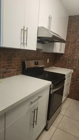 a stove top oven sitting inside of a kitchen