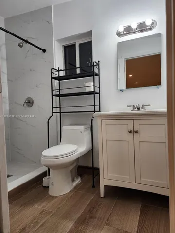 a bathroom with a toilet a sink and mirror