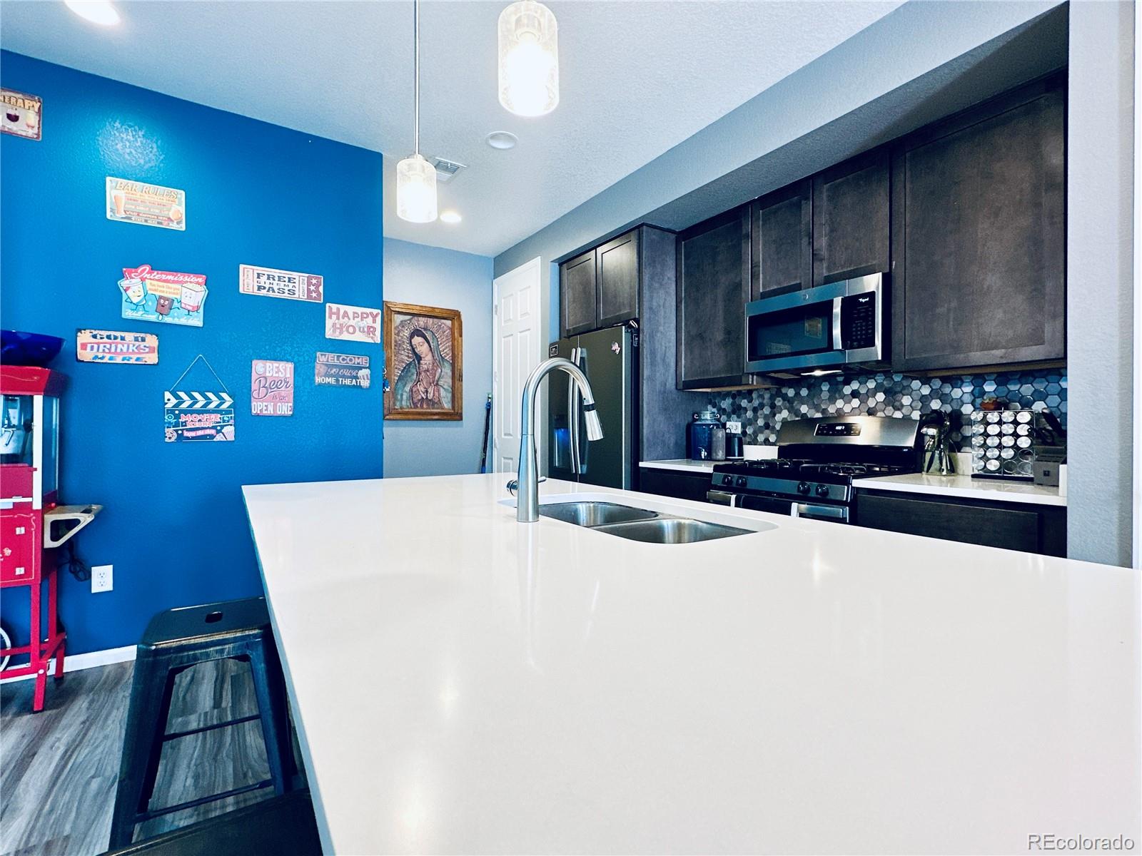 5337 Warrior Street Frederick, CO 80504 - Photo 3 of 17 a large kitchen with stainless steel appliances a large counter top a stove and a sink