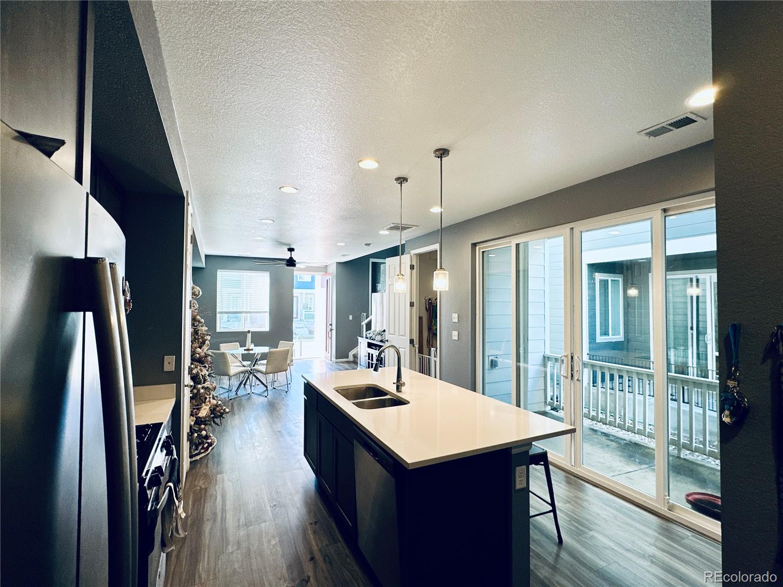 5337 Warrior Street Frederick, CO 80504 - Photo 5 of 17 a kitchen with stainless steel appliances a dining table chairs in it and wooden floor