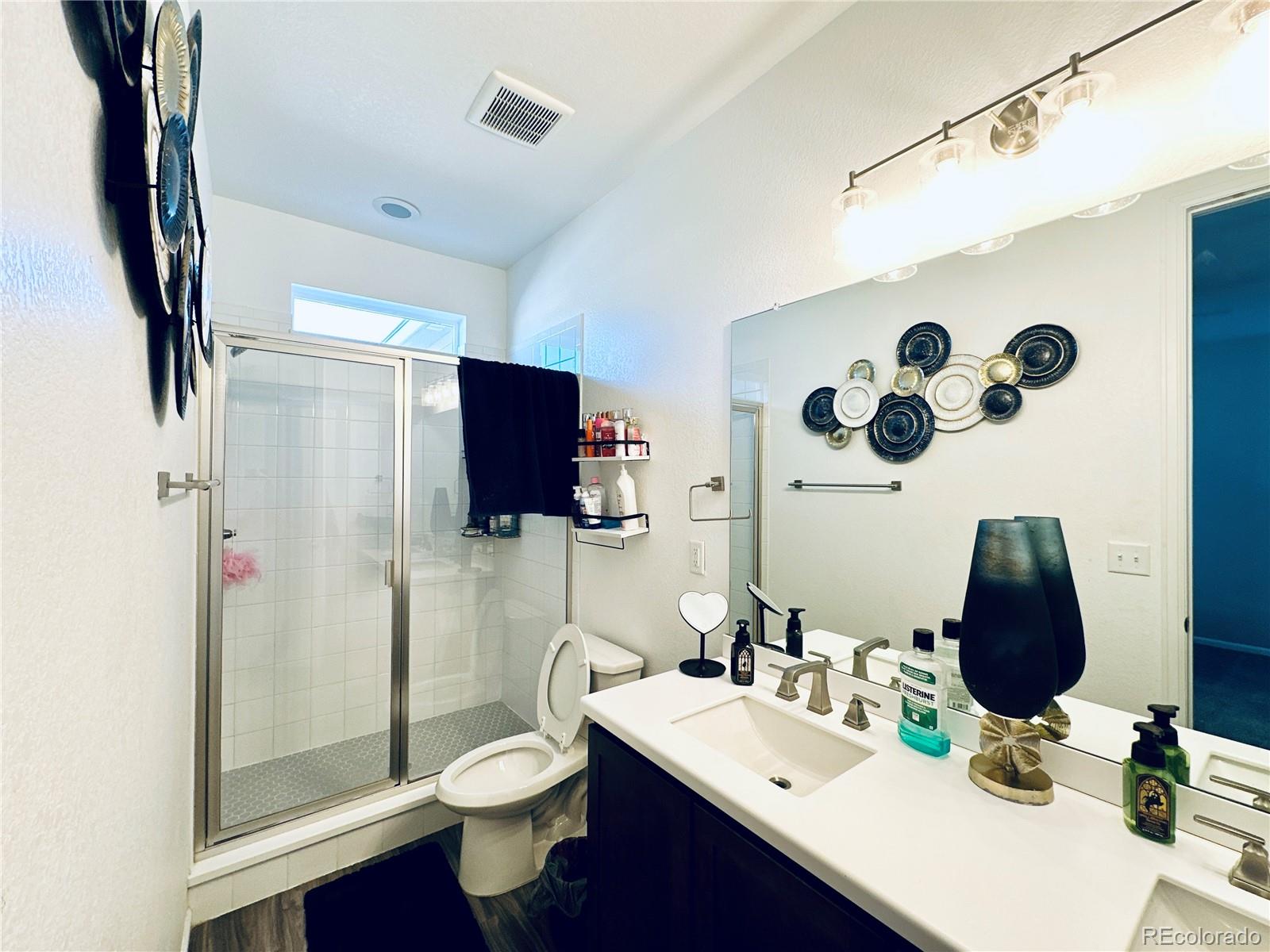 5337 Warrior Street Frederick, CO 80504 - Photo 10 of 17 a bathroom with a double vanity sink mirror and shower