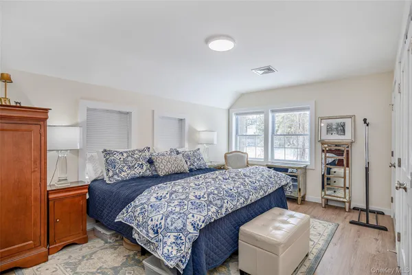 a bedroom with bed and wooden floor