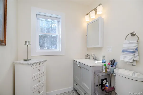 a bathroom with a sink a toilet and a window