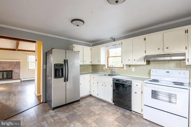a kitchen with granite countertop white cabinets and white appliances