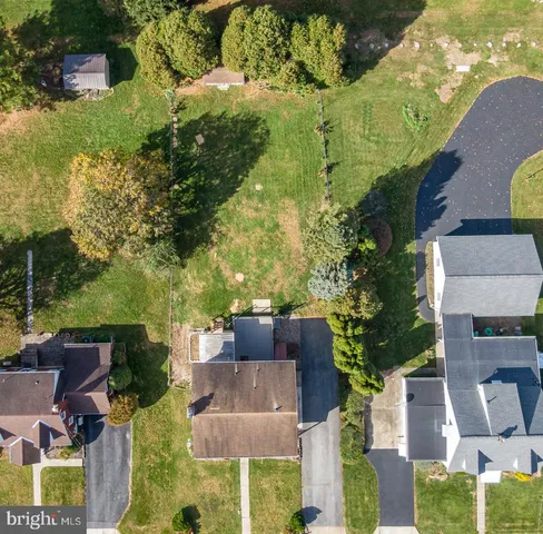 an aerial view of a house with a yard basket ball court and outdoor seating