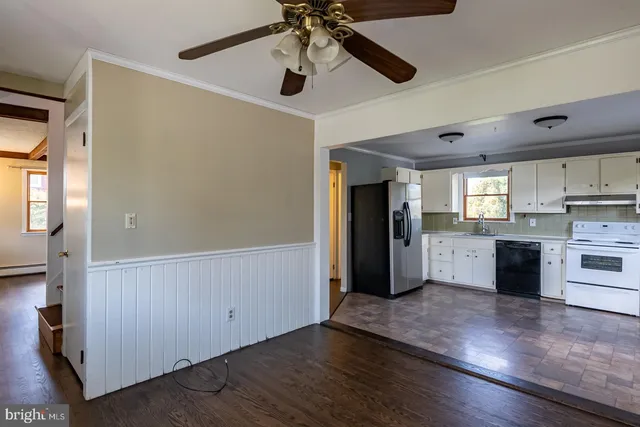 a view of a kitchen with wooden floor and a ceiling fan