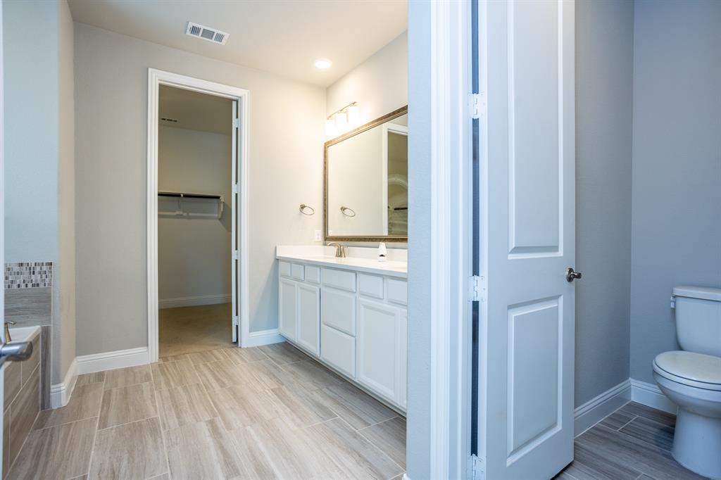 2436 Yosemite Way Corinth, TX 76210 - Photo 23 of 40 a bathroom with a sink and a large mirror