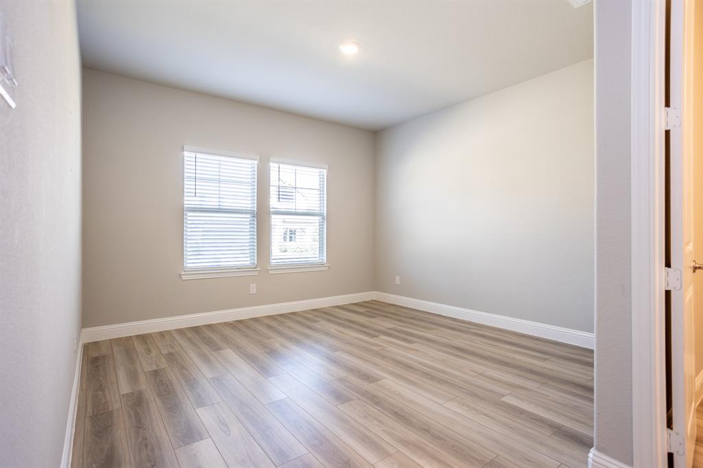 2436 Yosemite Way Corinth, TX 76210 - Photo 3 of 40 an empty room with wooden floor and windows