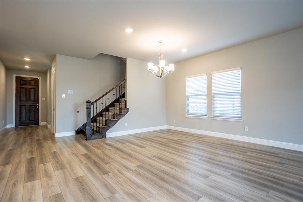 2436 Yosemite Way Corinth, TX 76210 - Photo 9 of 40 a view of an empty room with wooden floor and a window