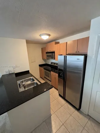 a kitchen with stainless steel appliances granite countertop a refrigerator and a stove