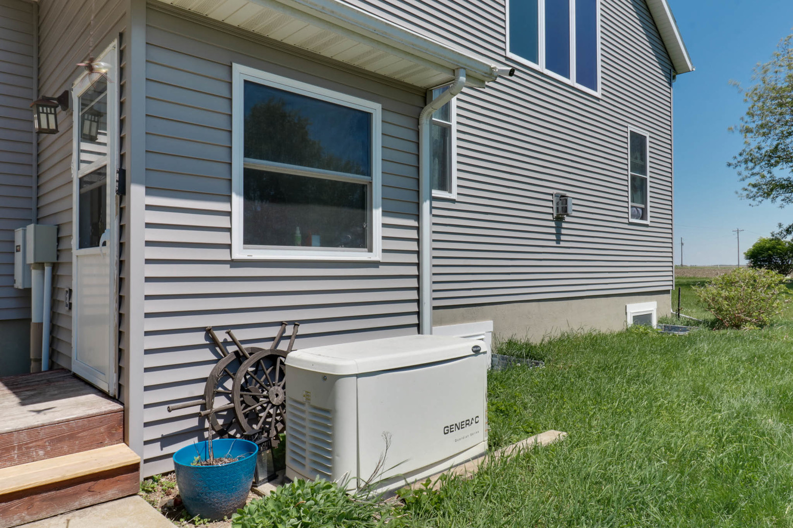12014 Prairie Center Road Clinton, IL 61727 - Photo 42 of 56 a backyard of a house with potted plants and a table