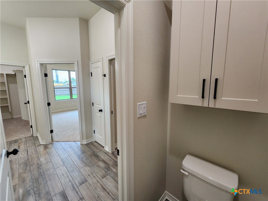 406 Talon Loop Salado, TX 76571 - Photo 25 of 31 a bathroom with a toilet and a wooden floor