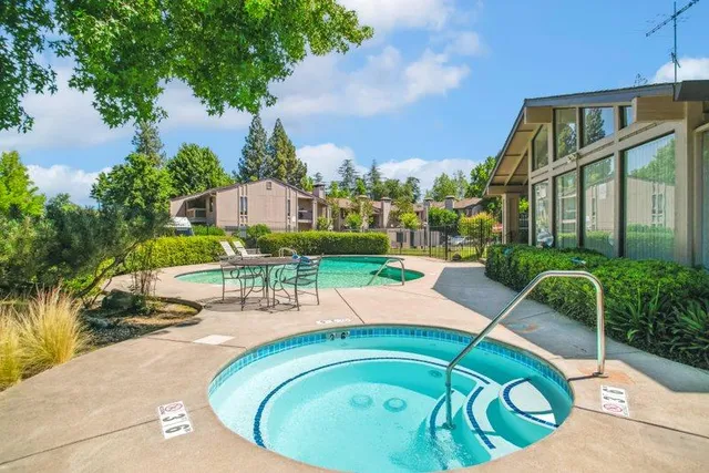 a view of a swimming pool with a patio and plants