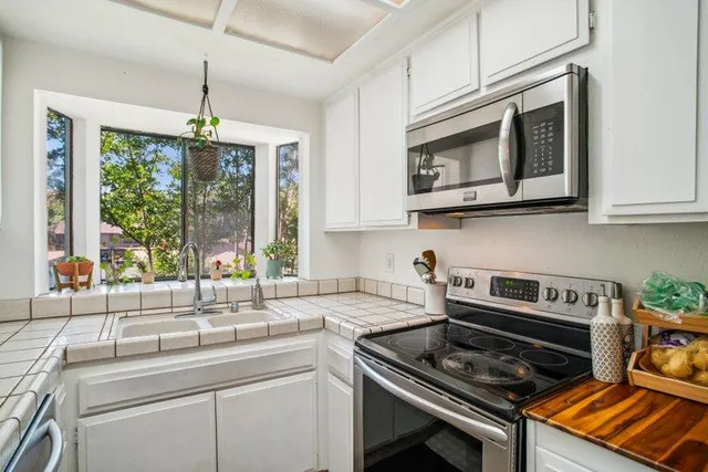 a kitchen with stainless steel appliances granite countertop a sink stove and cabinets