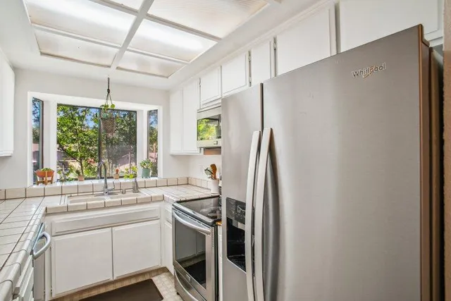 a kitchen with stainless steel appliances a refrigerator sink and window