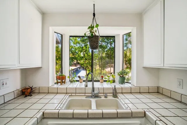 a kitchen with kitchen island granite countertop a large window cabinets and stainless steel appliances