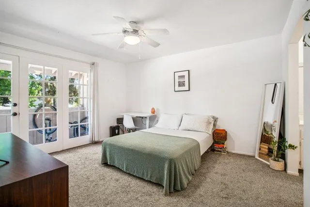 a bedroom with a bed and a couch next to a window