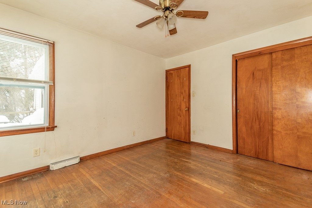 3303 River Road Perry, OH 44081 - Photo 18 of 34 Unfurnished bedroom featuring a closet, light wood-type flooring, a baseboard radiator, and ceiling fan