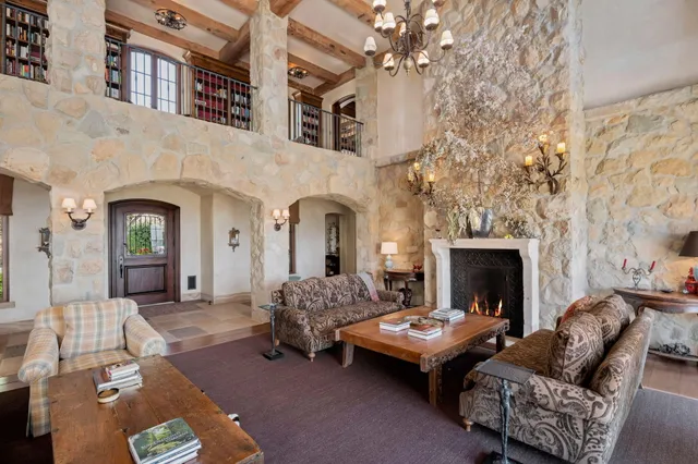 a living room with furniture a fireplace and a chandelier