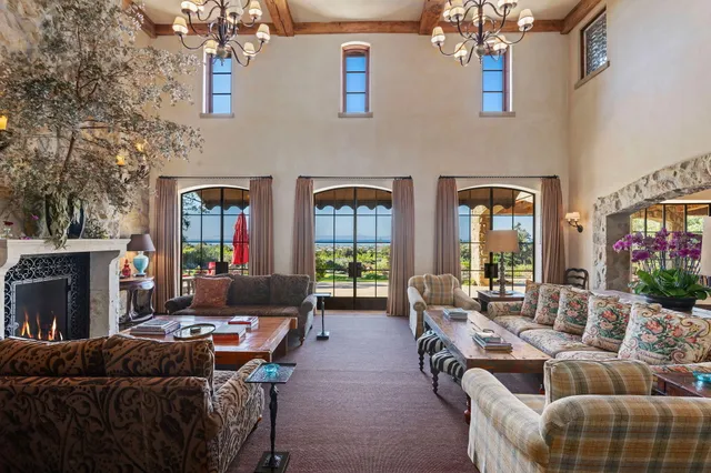 a living room with furniture a chandelier and a dining table