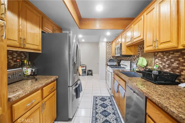 a kitchen with stainless steel appliances granite countertop a sink stove and refrigerator