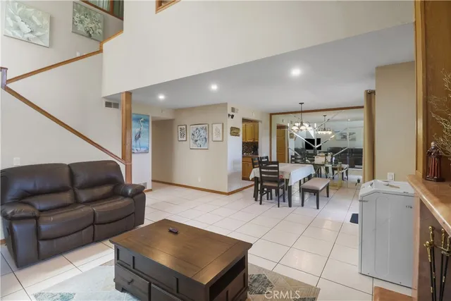 a living room with furniture and a dining table with potted plant