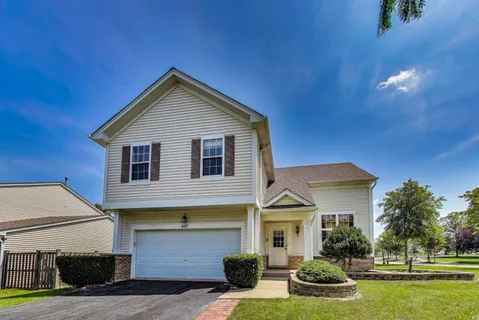 a front view of a house with a yard and garage
