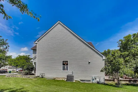 a backyard of a house with barbeque oven and seating space