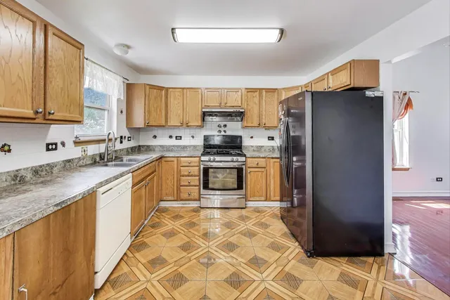 a kitchen with stainless steel appliances granite countertop a refrigerator stove top oven and sink