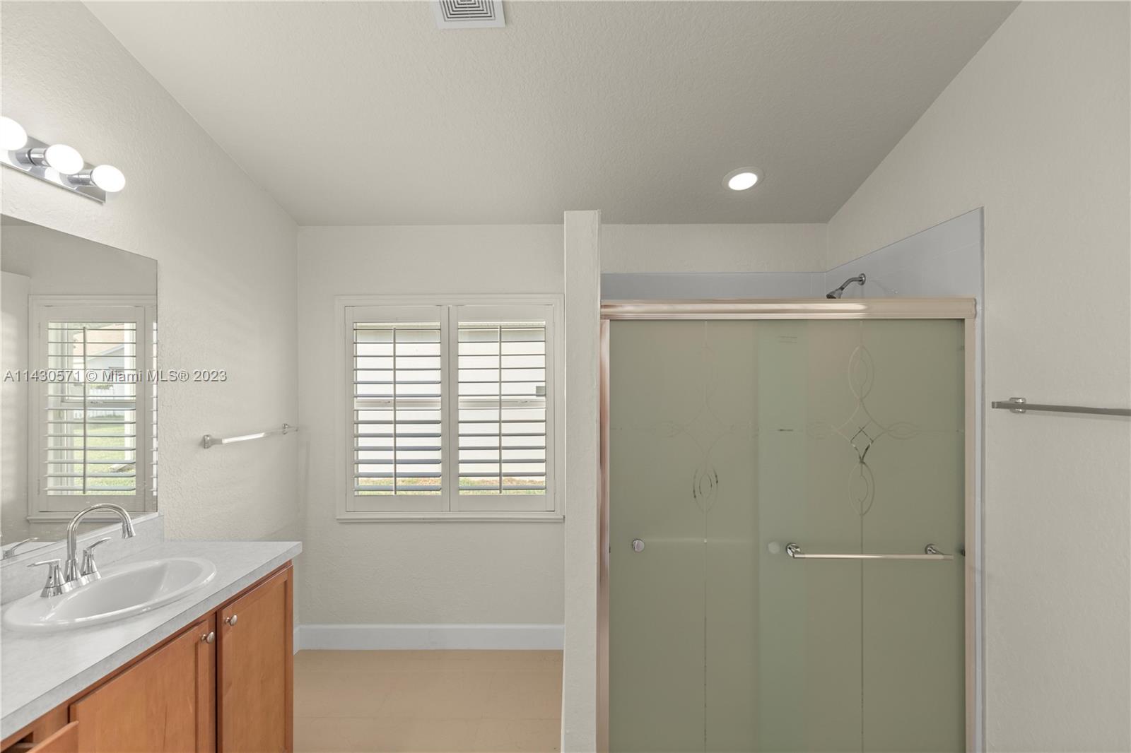 5453 Southwest 40th Street Ocala, FL 34474 - Photo 14 of 40 a bathroom with a shower sink and mirror
