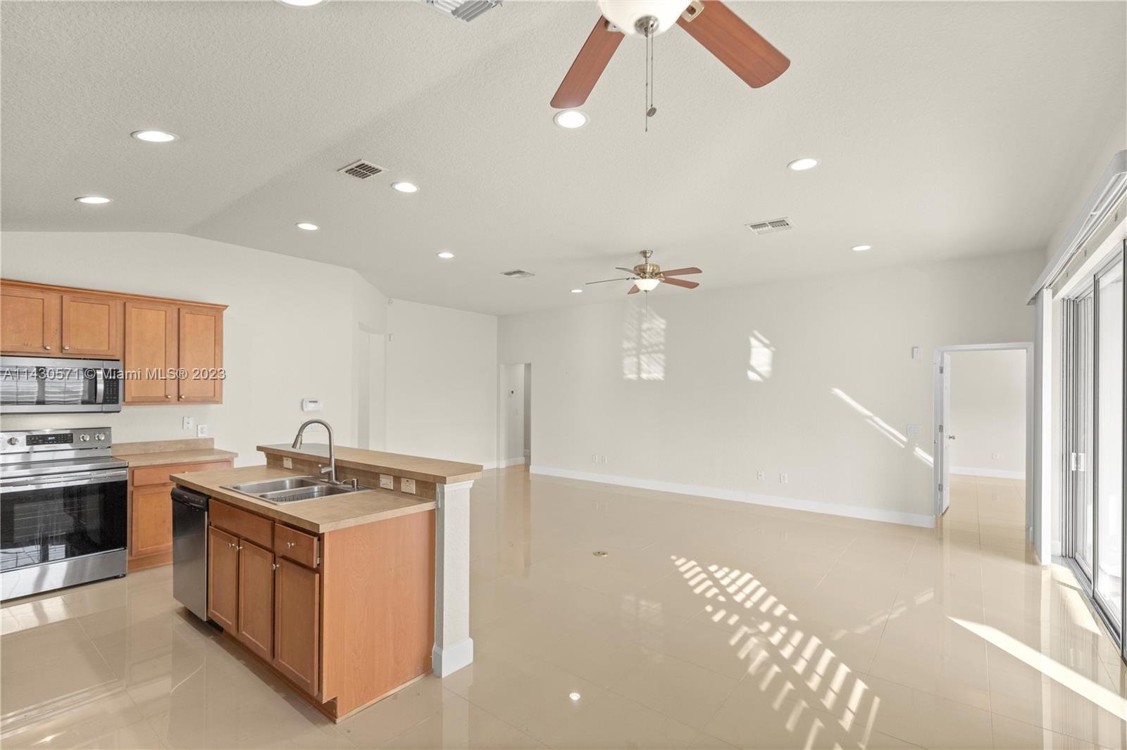 5453 Southwest 40th Street Ocala, FL 34474 - Photo 7 of 40 a kitchen that has a lot of cabinets in it and wooden floors
