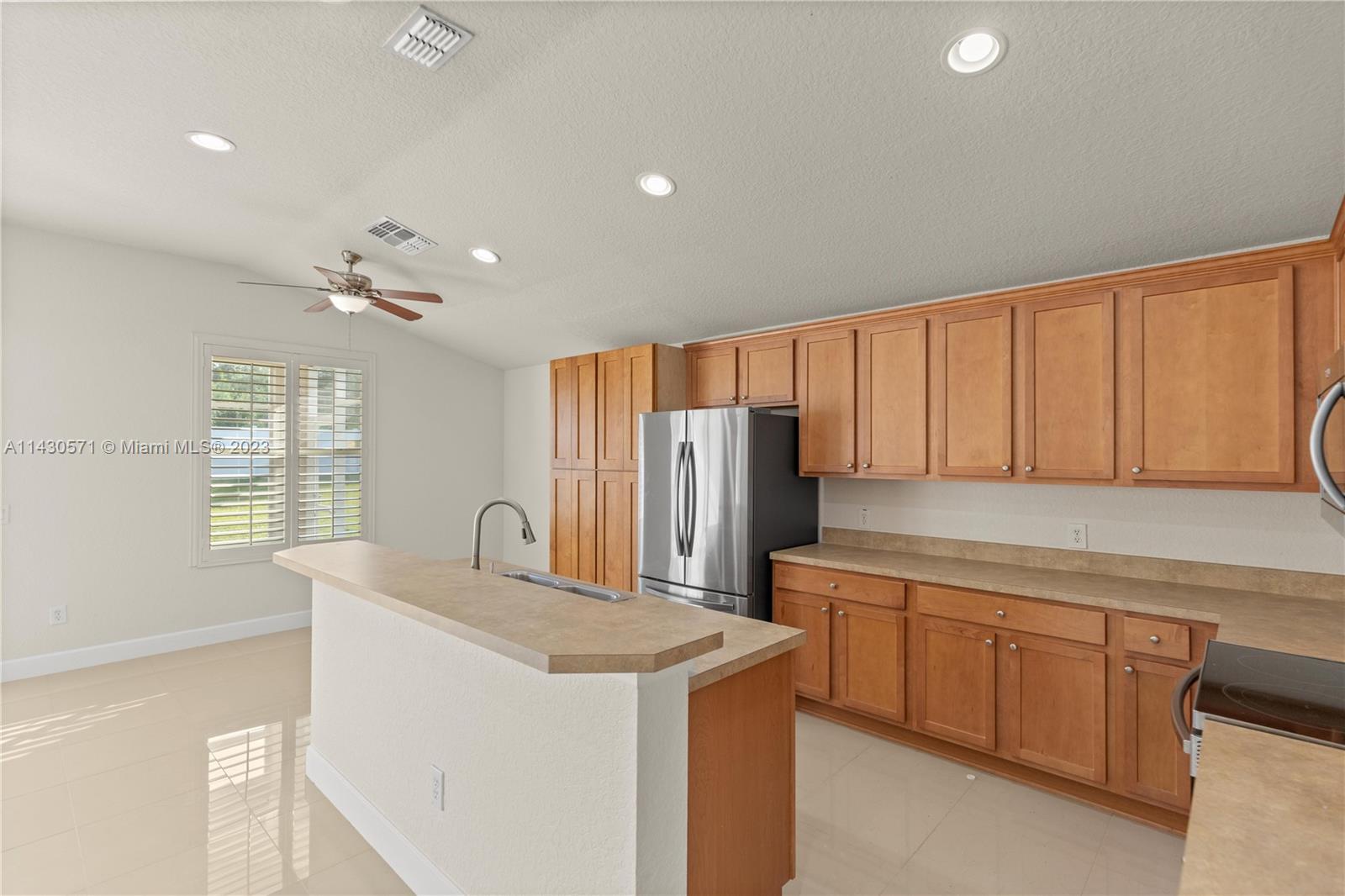 5453 Southwest 40th Street Ocala, FL 34474 - Photo 9 of 40 a kitchen with stainless steel appliances granite countertop a sink a stove and a refrigerator with wooden floor