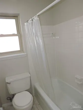 a white toilet sitting next to a bath tub