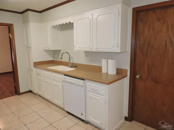 a kitchen with white cabinets and sink