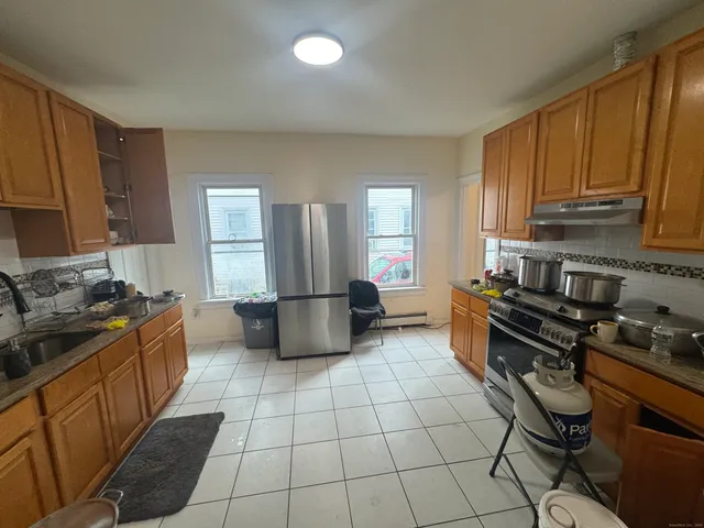 a kitchen with stainless steel appliances a stove a sink a microwave and a refrigerator