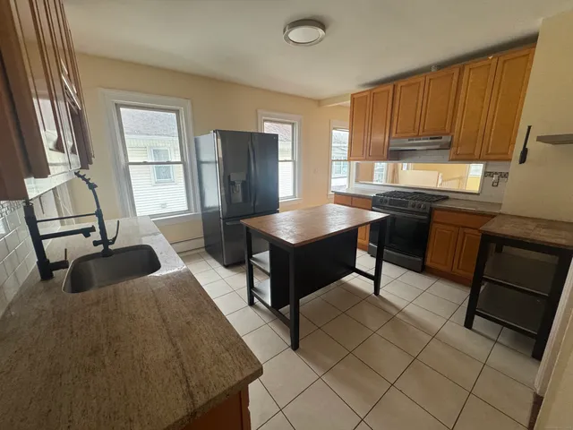 a kitchen with stainless steel appliances granite countertop a refrigerator sink and cabinets