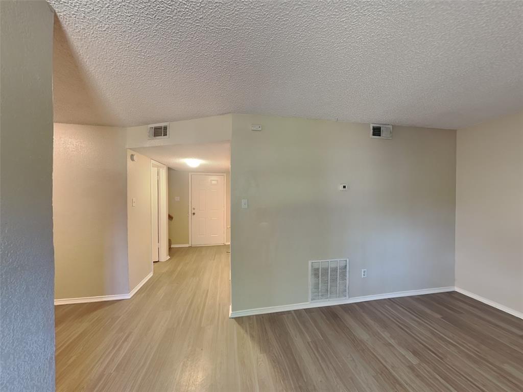 852 Northwest Summercrest Boulevard, Unit B Burleson, TX 76028 - Photo 3 of 13 a view of an empty room with wooden floor
