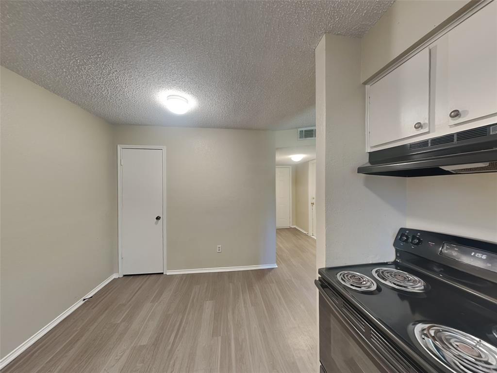 852 Northwest Summercrest Boulevard, Unit B Burleson, TX 76028 - Photo 4 of 13 a kitchen with a stove and a microwave