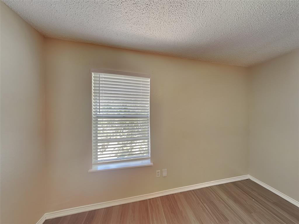 852 Northwest Summercrest Boulevard, Unit B Burleson, TX 76028 - Photo 10 of 13 a view of a small space with wooden floor and a window