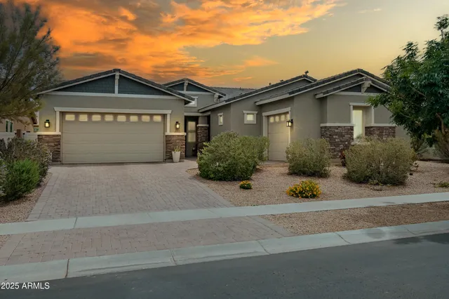 a front view of a house with garage and plants
