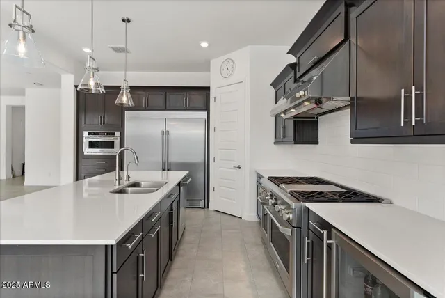 a kitchen with stainless steel appliances a refrigerator sink and microwave