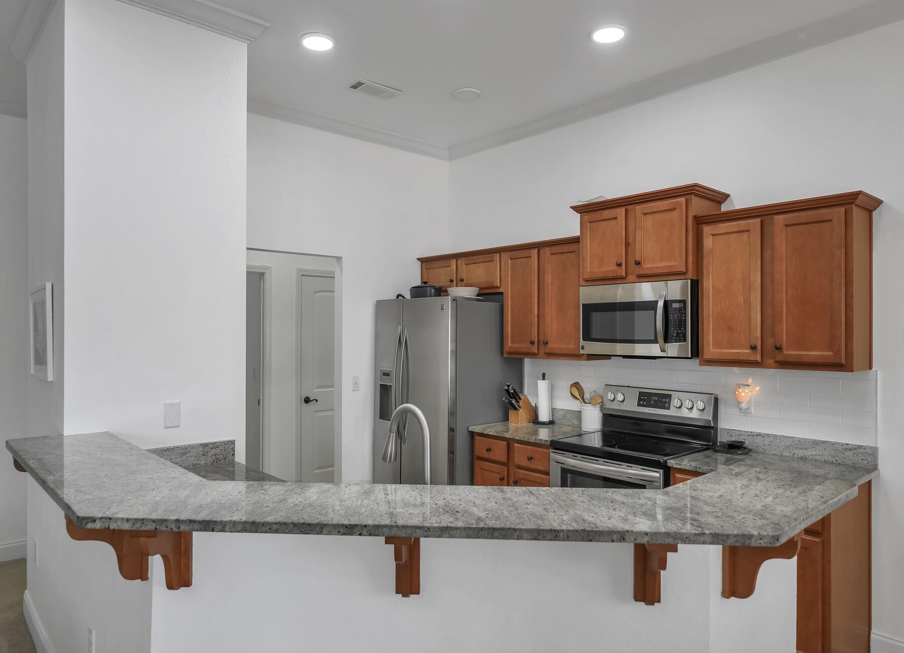 4413 Mirada Way Crestview, FL 32539 - Photo 7 of 30 a kitchen with stainless steel appliances granite countertop a sink a microwave a refrigerator and a stove