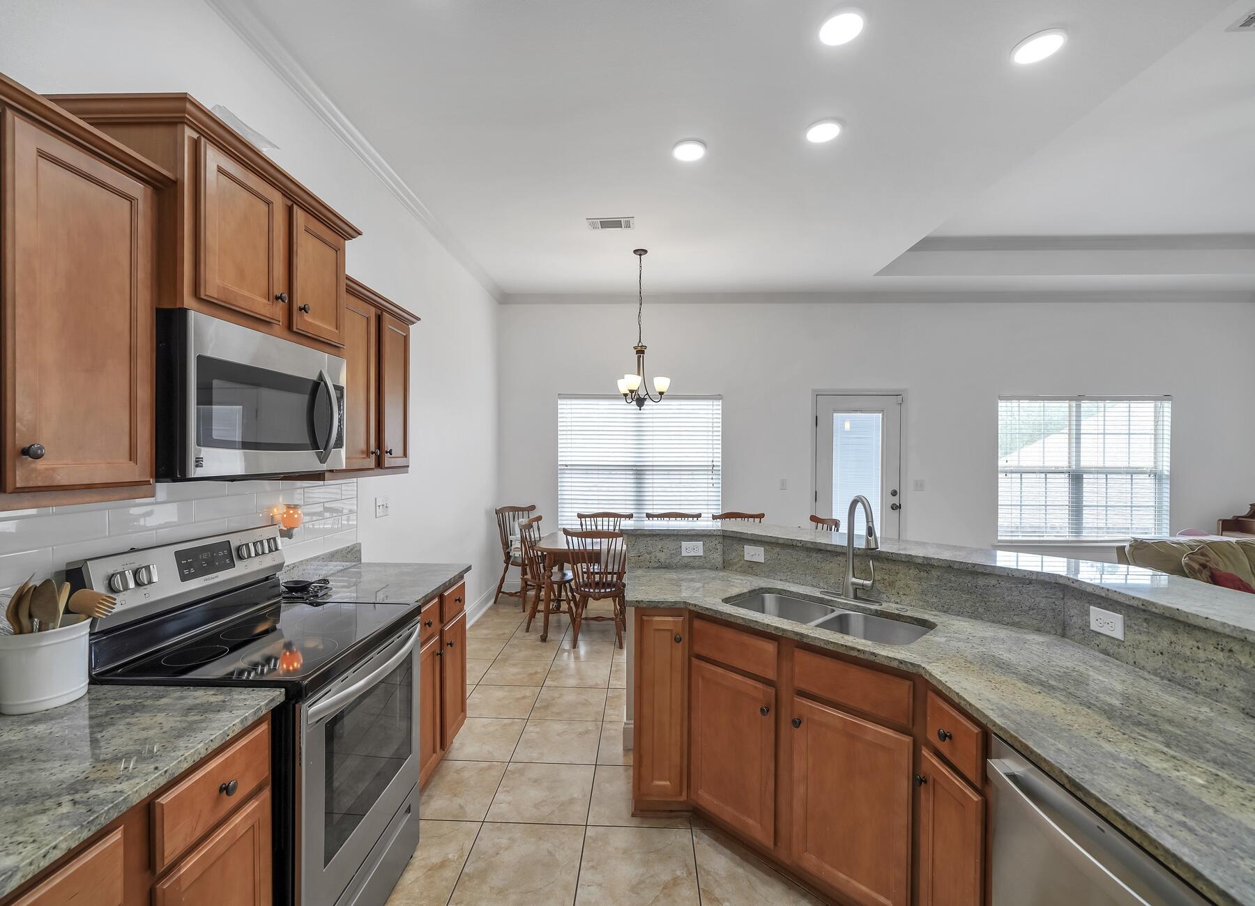 4413 Mirada Way Crestview, FL 32539 - Photo 9 of 30 a kitchen with stainless steel appliances granite countertop a sink stove and microwave