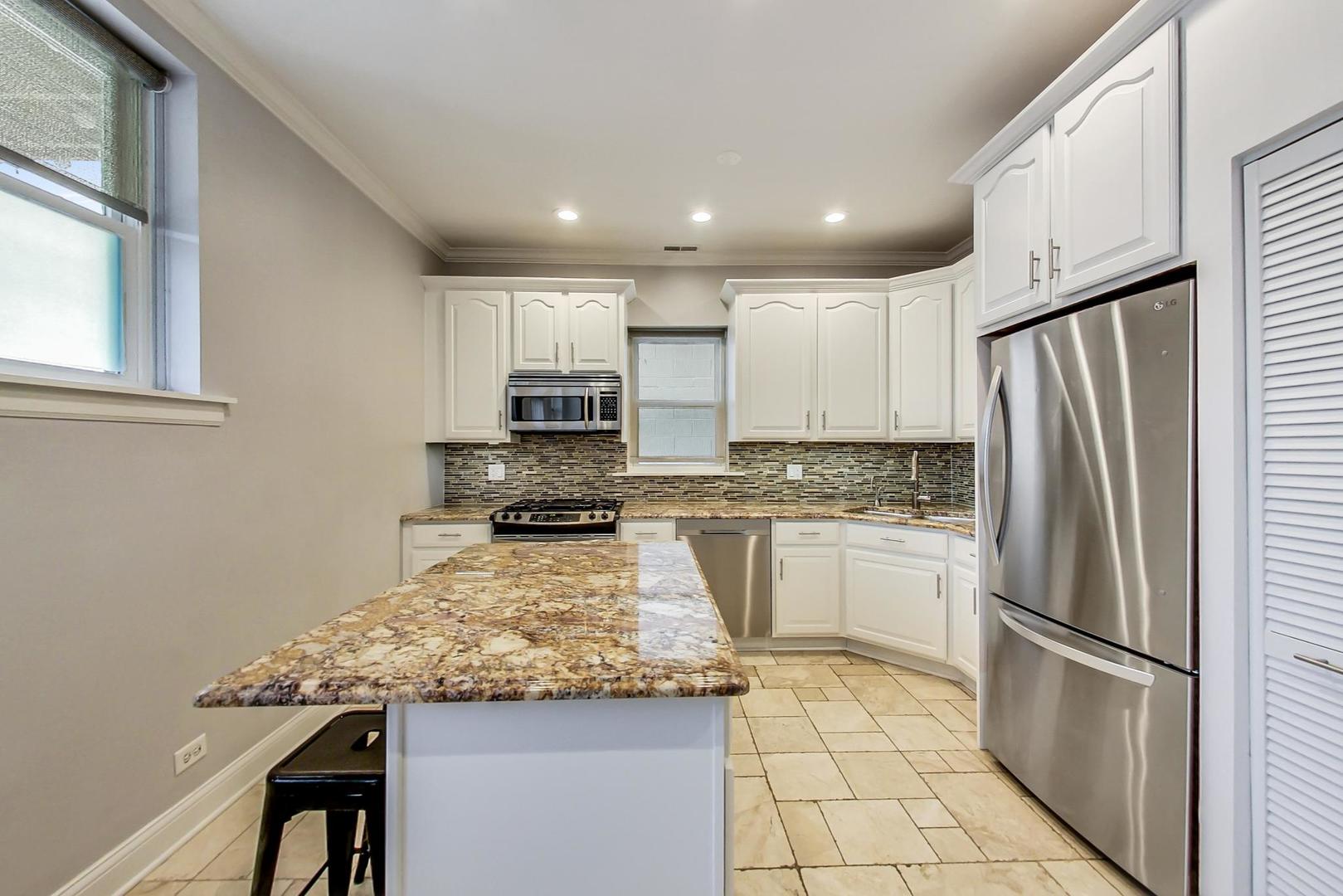 4342 North Sheridan Road, Unit 1N Chicago, IL 60613 - Photo 12 of 29 a kitchen with stainless steel appliances granite countertop a refrigerator sink and stove