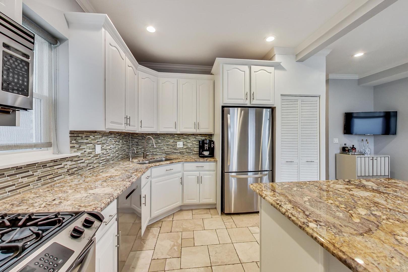 4342 North Sheridan Road, Unit 1N Chicago, IL 60613 - Photo 13 of 29 a kitchen with granite countertop a refrigerator and a stove top oven