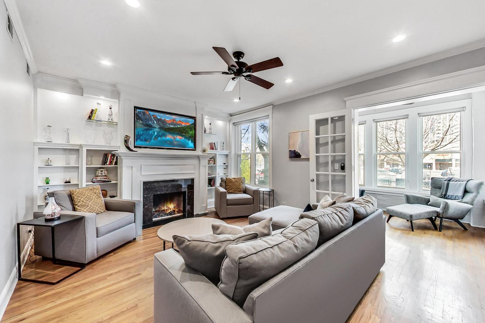 4342 North Sheridan Road, Unit 1N Chicago, IL 60613 - Photo 4 of 29 a living room with furniture fireplace and a large window