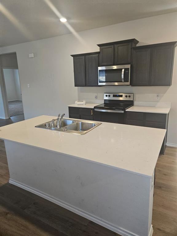 1520 Dilley Lane Forney, TX 75126 - Photo 5 of 26 a kitchen with stainless steel appliances a sink a stove a microwave and wooden cabinets
