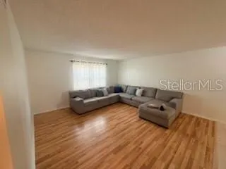 a living room with furniture and a hard wood floor